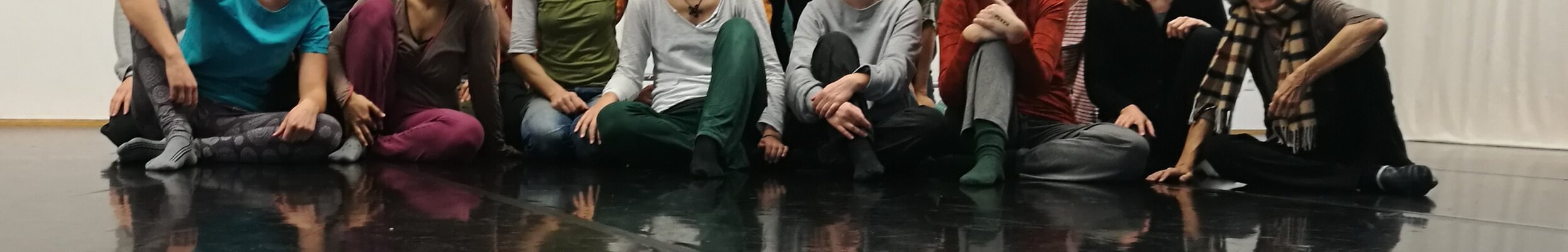 Bild von sitzenden Menschen in einer Gruppe man sieht nur die Beine und Oberkörper